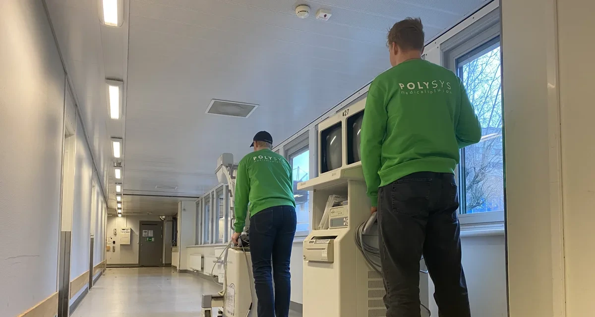 Polysys-tekniker transporterar medicinteknisk utrustning genom en sjukhuskorridor